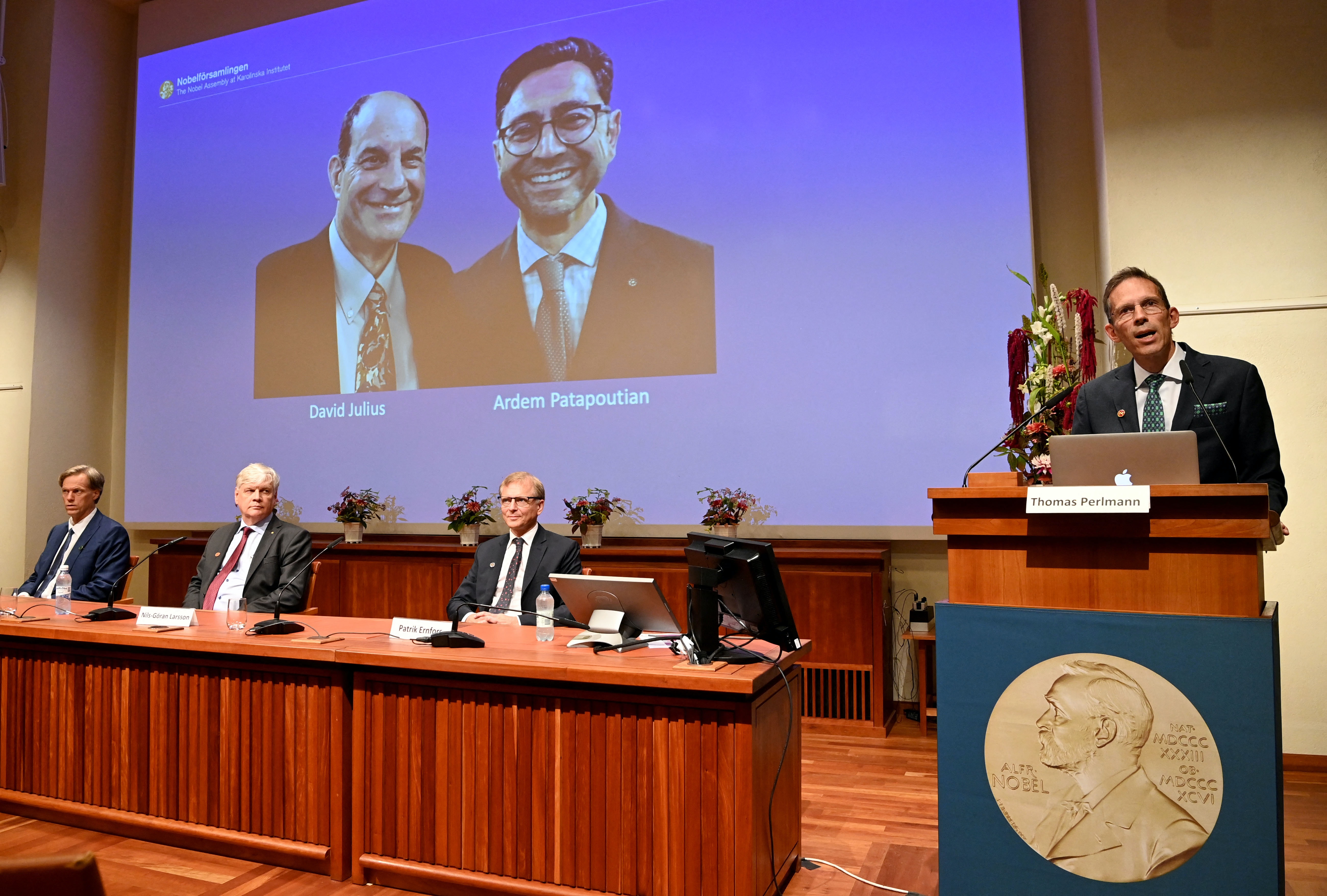 Large screen displaying the winners of the 2021 Nobel Prize in Physiology or Medicine