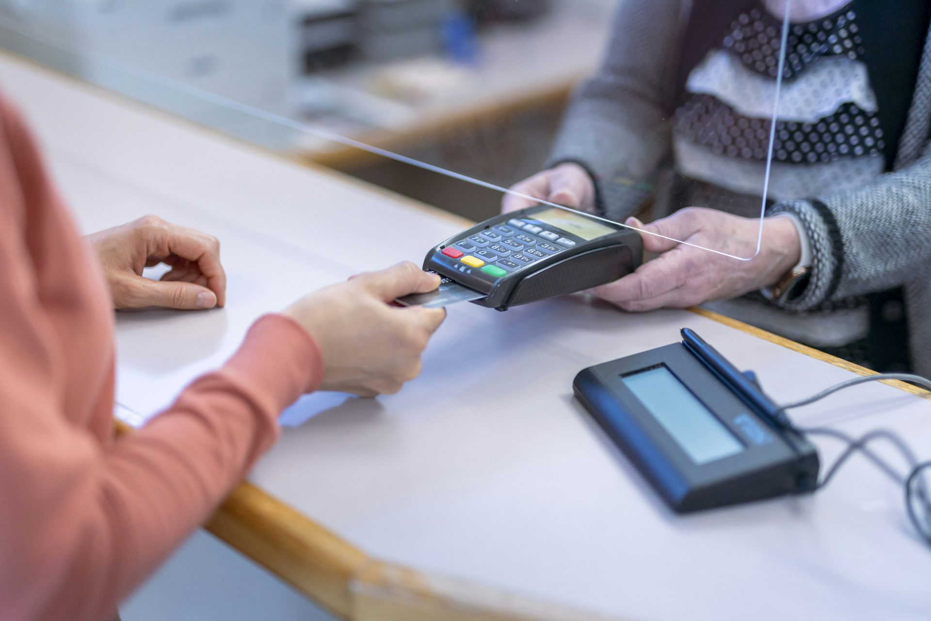 Person paying with credit card at front desk of medical office