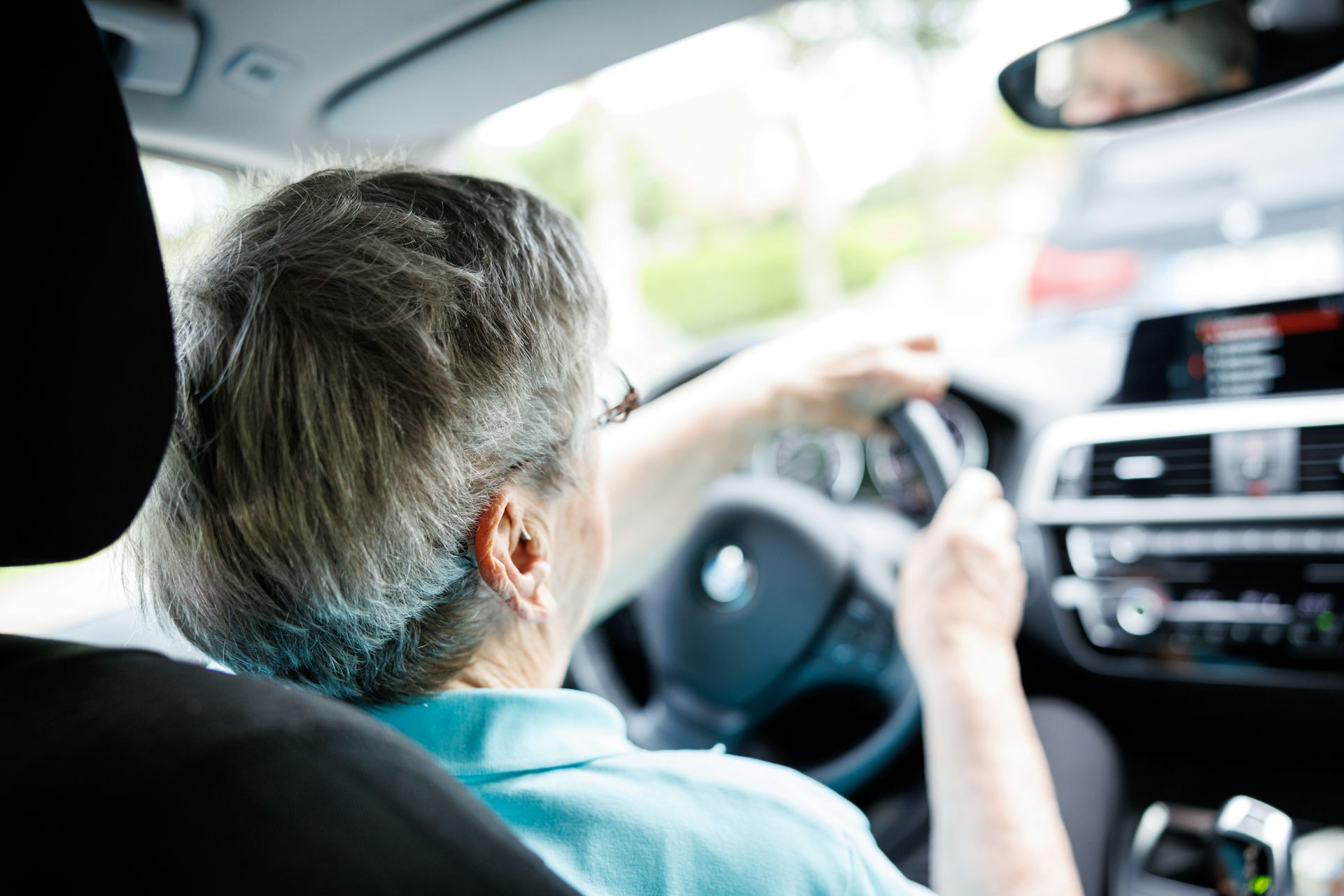 Elderly woman behind the wheel of a car.