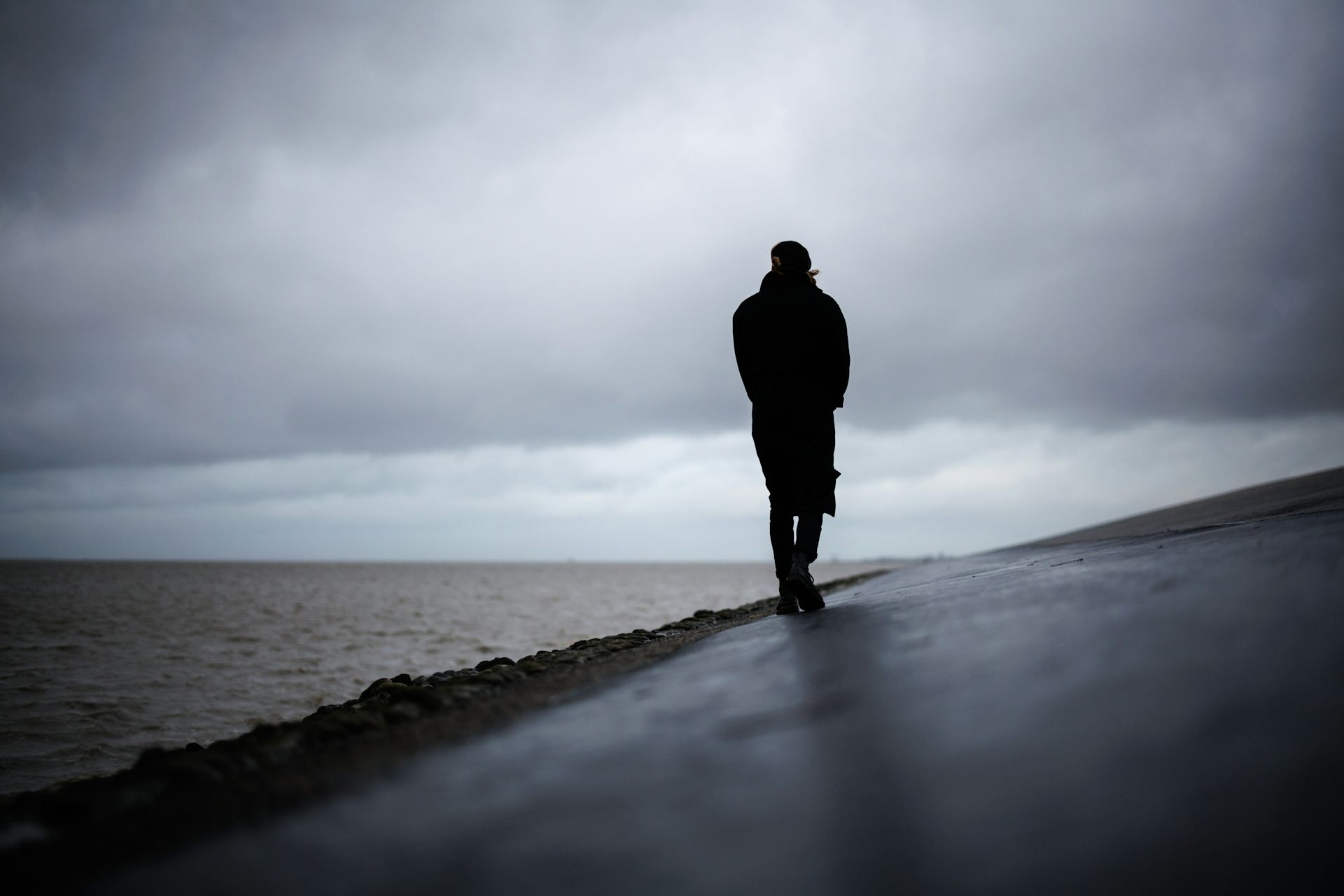 Man walks alone along beach.