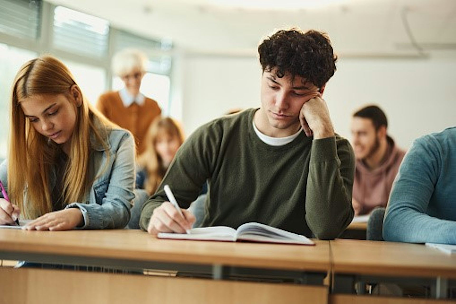 In a classroom setting, students take an exam.